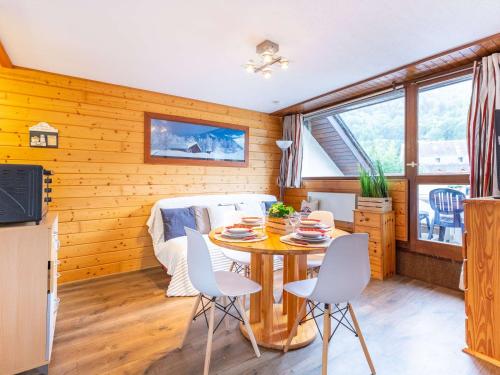 une cuisine et une salle à manger avec une table et des chaises dans l'établissement Appartement pour 4 personnes avec balcon et garage, proche téléphérique et commerces à Saint-Lary - FR-1-296-478, à Saint-Lary-Soulan