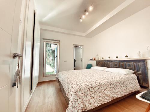 a white bedroom with a bed and a window at Casa Cactus in Corralejo