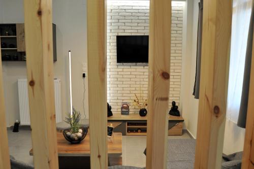 a living room with a tv on a white brick wall at Meteora's unique gem in Kastrákion