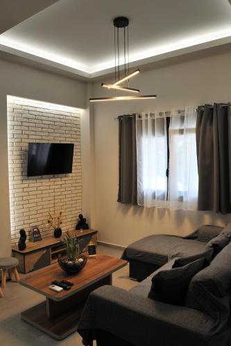 a living room with a couch and a tv on the wall at Meteora's unique gem in Kastrákion