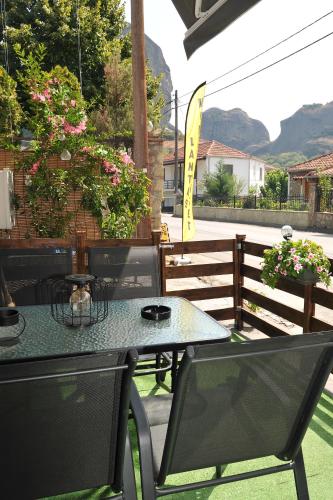a table and chairs on a patio with a fence at Meteora's unique gem in Kastrákion