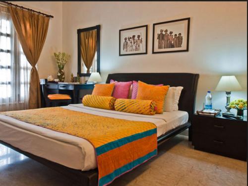 a bedroom with a large bed with colorful pillows at Colonel’s Retreat in New Delhi