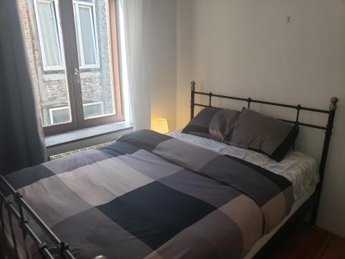 Appartement bien-être في لييج: سرير في غرفة نوم مع نافذة كبيرة