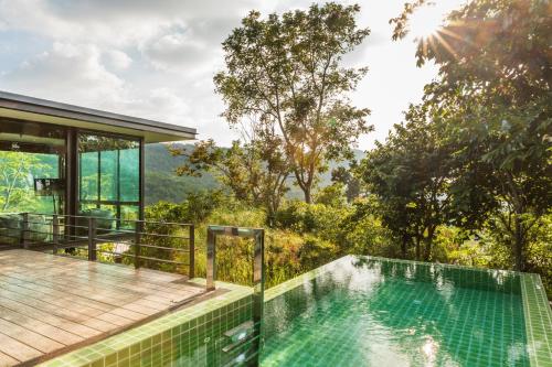 een huis met een zwembad en een terras bij The Paz Khao Yai in Nong Sarai