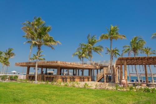 een huis aan het strand met palmbomen bij BM Beach Resort in Ras al Khaimah