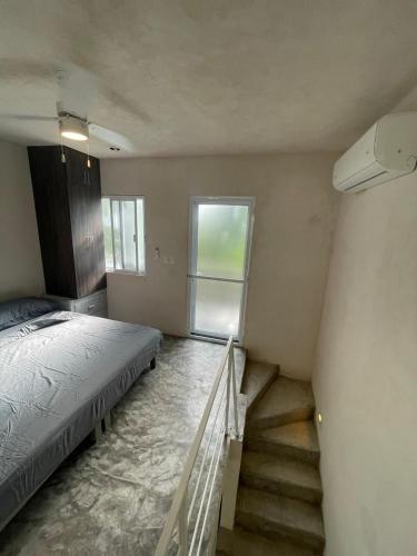 1 dormitorio con 1 cama y escalera con ventana en Tulum Loft, en Tulum