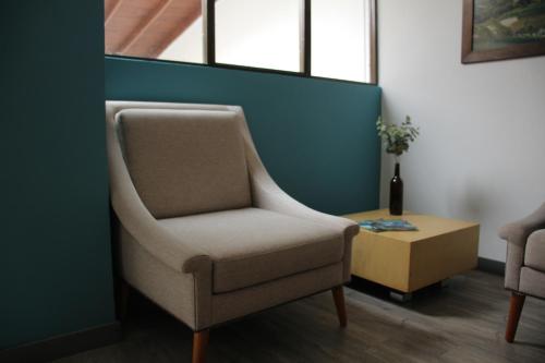 a living room with a chair and a table at Hotel Plaza El Santuario in Santuario