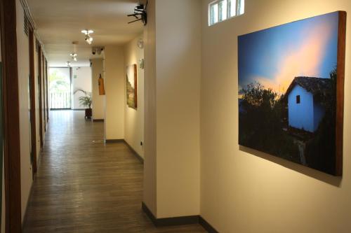 a hallway with a painting of a house on the wall at Hotel Plaza El Santuario in Santuario
