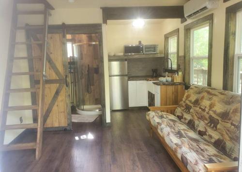 a living room with a couch and a kitchen at Waterfront Treehouse in a Magical Forest in Waller