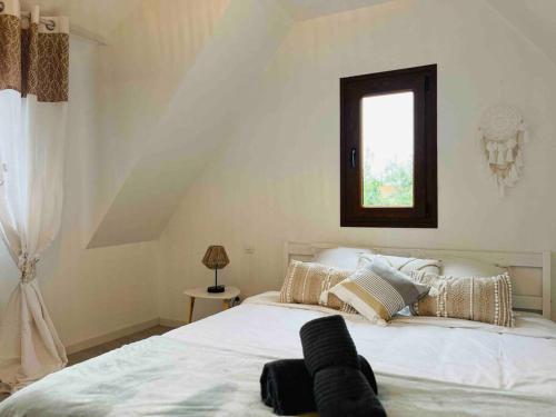 una camera da letto con un grande letto bianco e una finestra di S'Hiesele petite maison alsacienne typique a Ittenheim