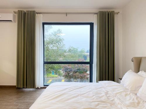 a bedroom with a bed and a large window at Forest City Golf Course Resort Villa by Lions Bay in Gelang Patah