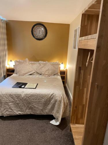 1 dormitorio con 1 cama con reloj en la pared en The Bell Inn, en Salisbury