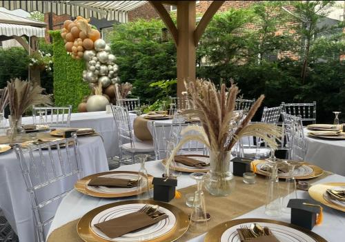 a table set up for a dinner party with white table settings at Hendham House in Manchester
