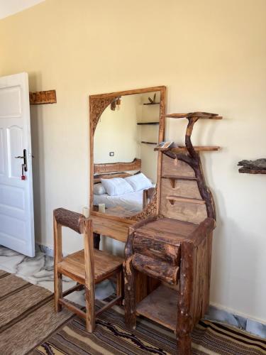 a bedroom with a mirror and a chair and a bed at People to People Siwa in Siwa