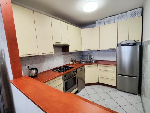 a kitchen with white cabinets and a stainless steel refrigerator at Dwupokojowe mieszkanie Nowy Dwór Mazowiecki in Nowy Dwór Mazowiecki