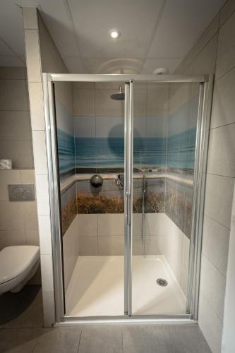 a shower with a glass door in a bathroom at Hotel Mercedes in Hossegor
