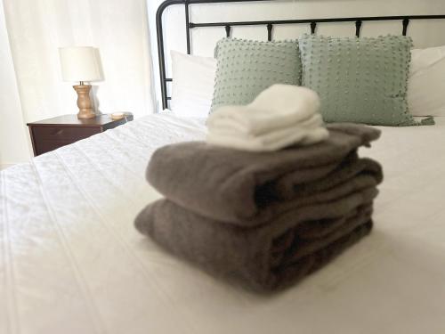 a pile of towels sitting on top of a bed at Dwntwn Custer Farmhouse On Main St With Hot Tub in Custer