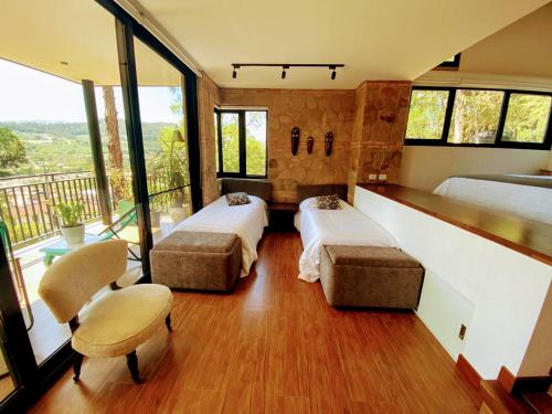een slaapkamer met 2 bedden en een balkon bij La Vista - Un lugar de Ensueño in Samaipata