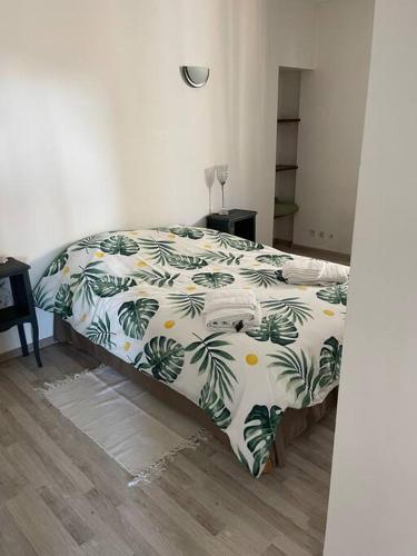 - une chambre avec un lit et une couette verte et blanche dans l'établissement L'appart de la plage du Casino, à Saint-Quay-Portrieux