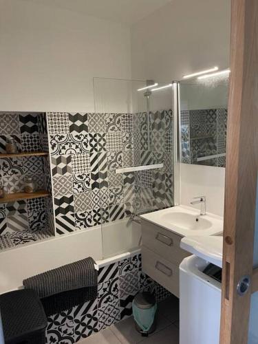 La salle de bains est pourvue d'un lavabo et d'un miroir. dans l'établissement L'appart de la plage du Casino, à Saint-Quay-Portrieux