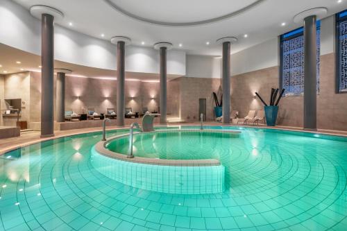 a large swimming pool in a hotel lobby at Palácio Estoril Hotel, Golf & Wellness in Estoril