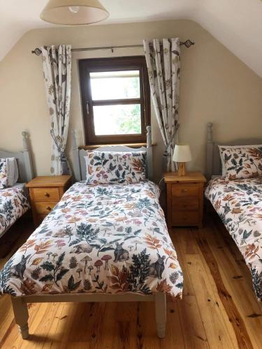 1 dormitorio con 2 camas y ventana en 2 Ballyloskey Road en Carndonagh