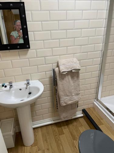 a white bathroom with a sink and a mirror at The Bell Inn in Salisbury