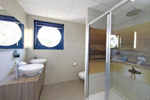 a bathroom with a shower and a sink and a toilet at Hotel Mercedes in Hossegor