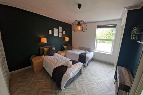 een woonkamer met een bed en een raam bij Spacious House with 4-Room Sleeps 8 Ideal for Contractors & Groups ,Family - Smart TV - Netflix - Parking - Birmingham 20min M6 J9 in Wednesbury
