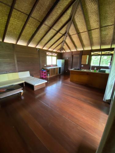 een grote kamer met een bank en houten vloeren bij Chalet Mahina in Mahina