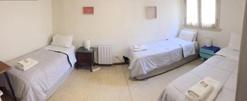 three beds in a room with white walls at Casa Nanet Hotel in Mar del Plata