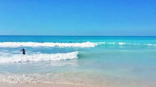 a person standing in the water at the beach at Beachfront Holiday Homes in Ajman 