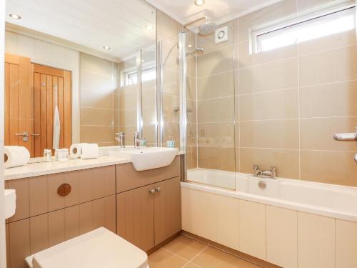 bagno con lavandino, vasca e servizi igienici di Langham a Cottesmore