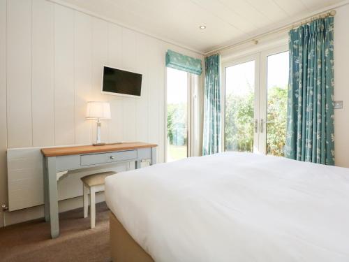 una camera con letto, scrivania e finestra di Langham a Cottesmore