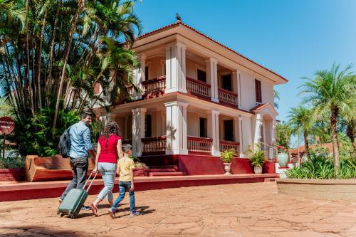 a family walking in front of a house with luggage at Hotel Fazenda Salto Grande in Araraquara