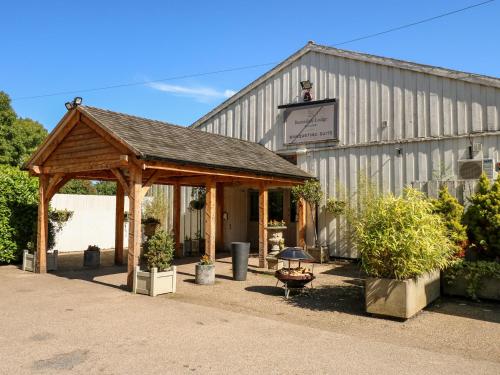 a building with a wooden pavilion in front of it at Hambleton in Cottesmore