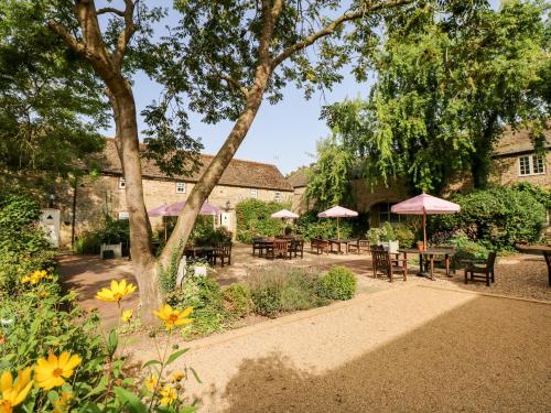 a garden with tables and umbrellas in front of a building at Hambleton in Cottesmore