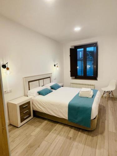 Un dormitorio con dos camas y una ventana. en Apartamentos Rurales La Plaza 3, en Duruelo de la Sierra