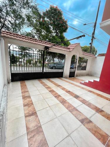 a black gate in a house with a tile floor at Casa con Habitaciones privadas in Guayaquil