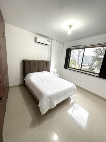 a bedroom with a bed in a room with a window at Casa con Habitaciones privadas in Guayaquil