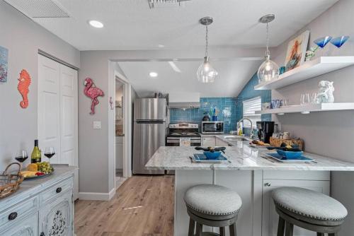 una cocina con una isla con 2 taburetes en Downtown Dunedin Gem, Fully Renovated #4, en Dunedin