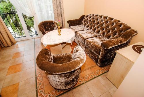 a living room with a couch and a table and chairs at Saulės Krantas in Palanga