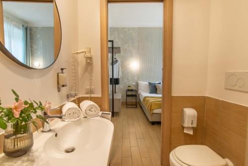 a bathroom with a sink and a toilet and a mirror at 94Rooms Vatican Guest House - Vigliena in Rome