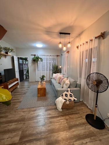 a living room with a couch and a fan at Casa Privado- 2 Bedroom House Near the Airport in Puerto Princesa City