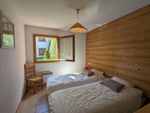 une chambre avec deux lits et une fenêtre dans l'établissement Appartement 3 pièces avec terrasse et garage, proche ski, La Clusaz - FR-1-459-100, à La Clusaz