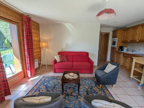 un salon avec un canapé rouge et une table dans l'établissement Appartement 3 pièces avec terrasse et garage, proche ski, La Clusaz - FR-1-459-100, à La Clusaz