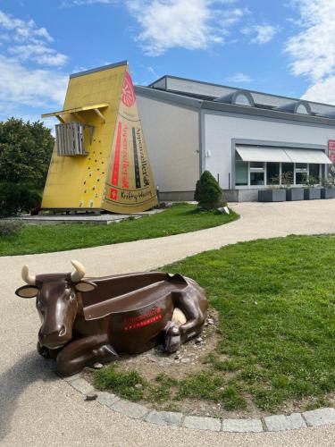 a statue of a cow on the grass in front of a building at Ferienwohnung in Stein AR in Stein