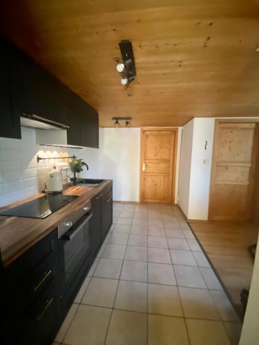 a kitchen with black cabinets and a wooden ceiling at Ferienwohnung in Stein AR in Stein