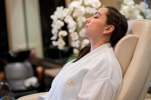 a woman sitting in a chair with her head up at Wyndham Grand Cancun All Inclusive Resort & Villas in Cancún