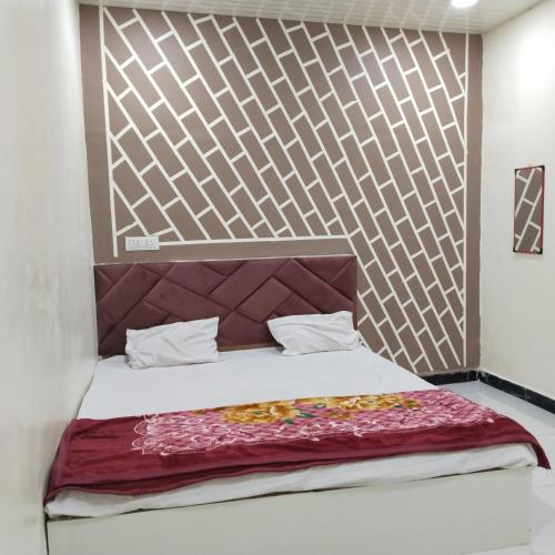 1 dormitorio con 1 cama con cabecero de madera en Hotel shree Gajanand palace, en Ujjain